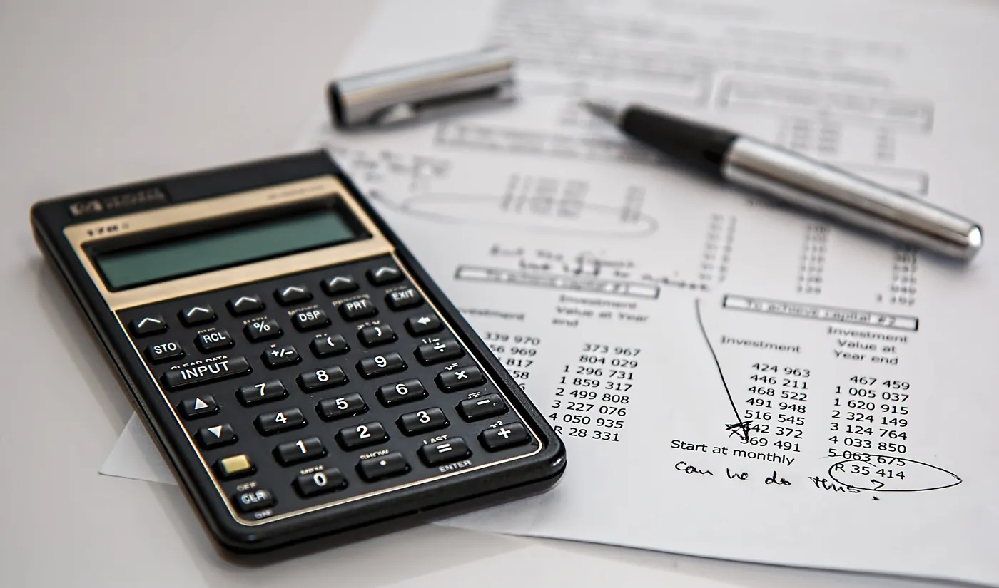 A calculator and pen on financial papers