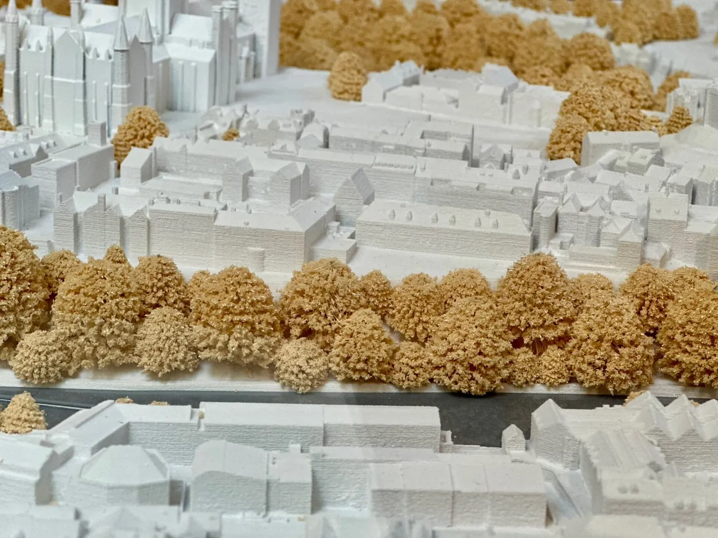 A white architectural model of a city block