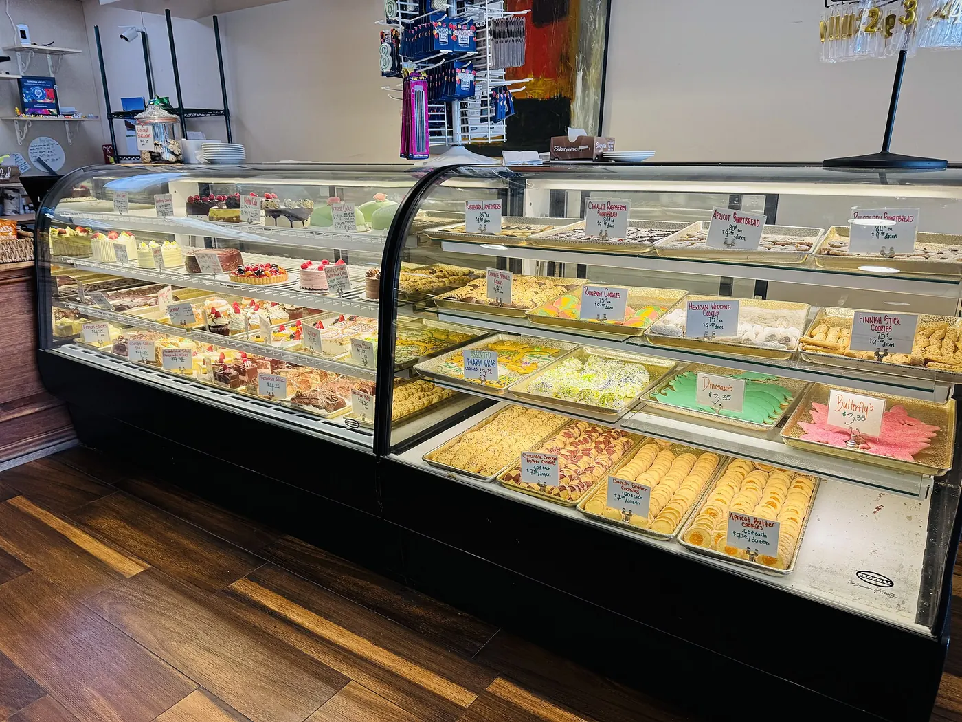 A glass bakery counter full of cakes