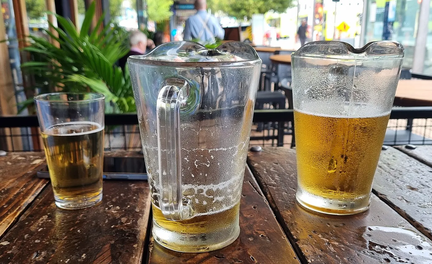 Glasses of beer on a wooden bar table