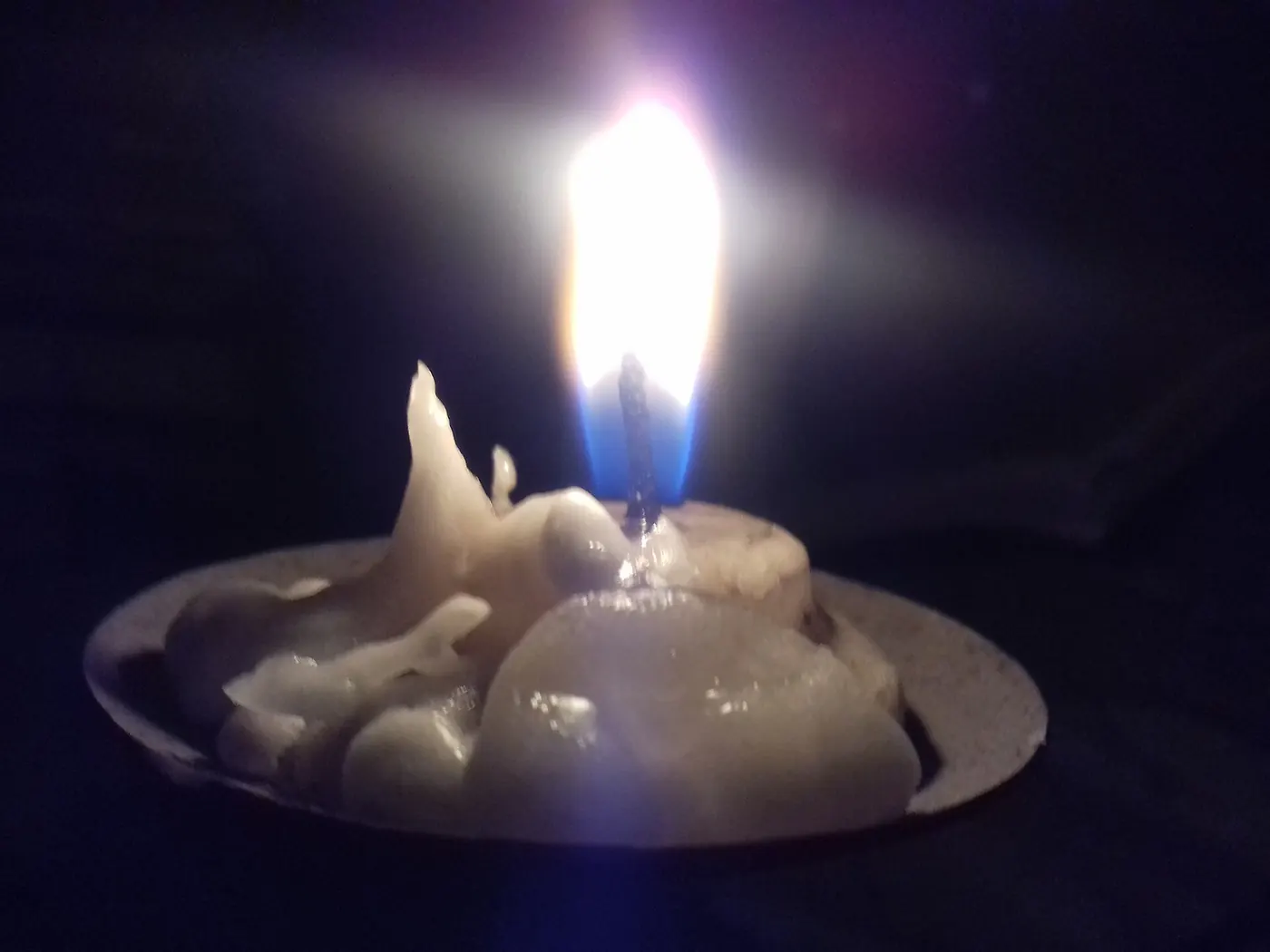 A candle flame glowing in the dark