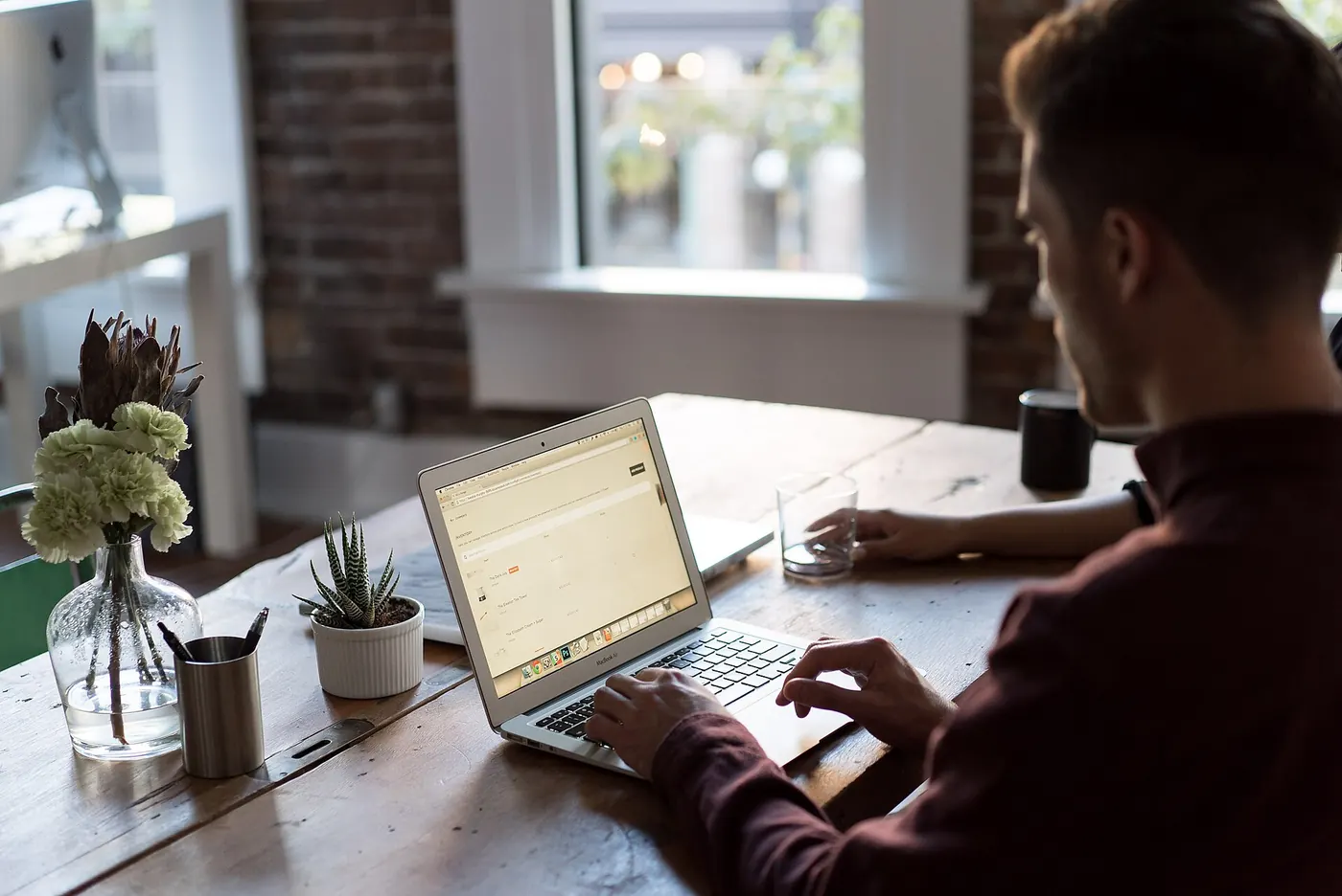 A man working at a laptop by a window