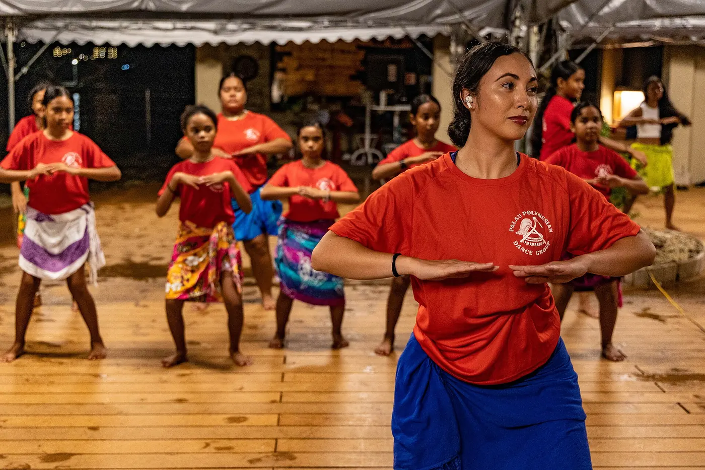 A dance teacher leading a class of young dancers