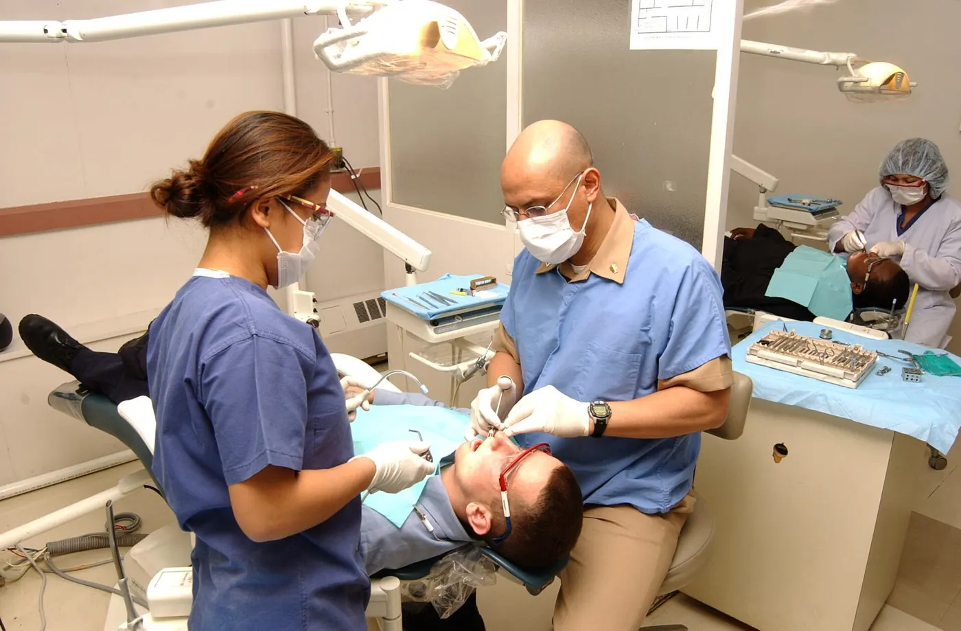 A dentist and assistant treating a patient in a dental surgery