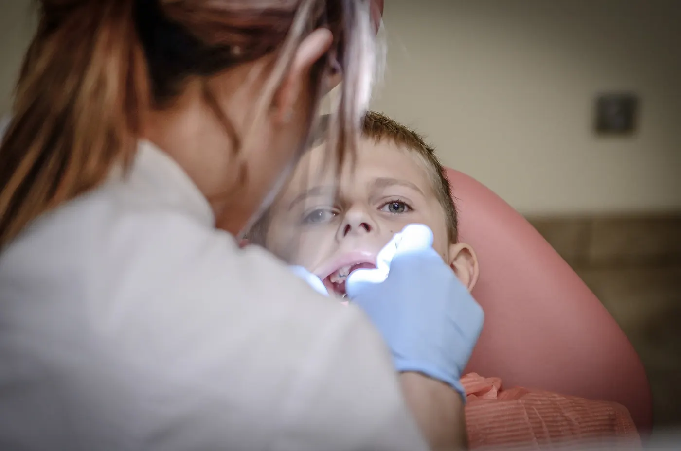 A dentist examining a young patient's teeth