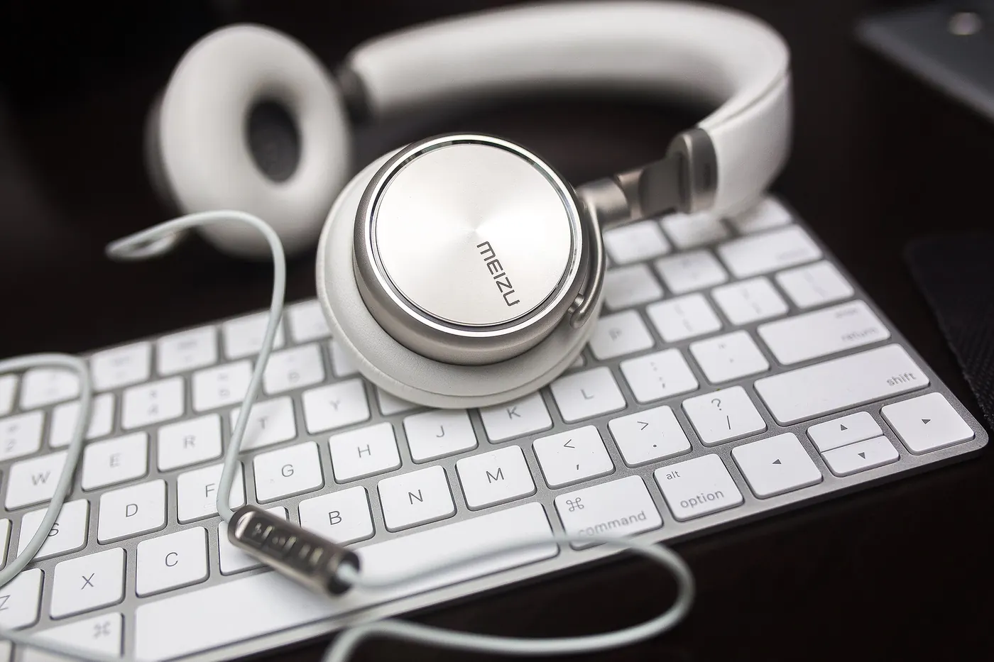 White headphones resting on a keyboard