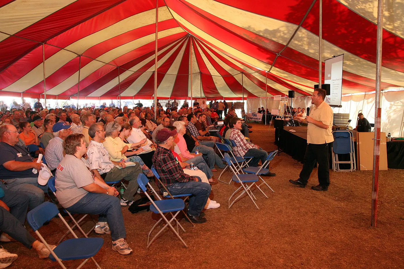 A striped event marquee full of guests