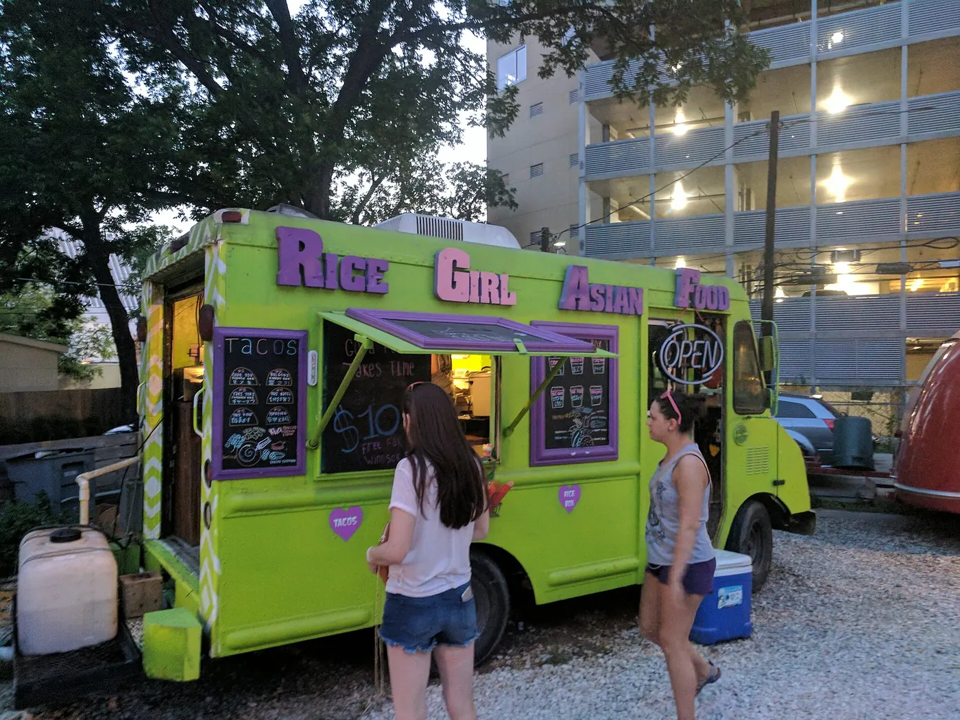 A bright green food truck serving customers