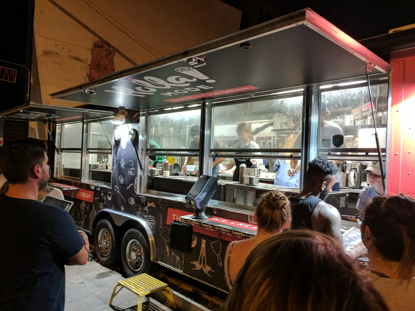 A queue at a food truck at night