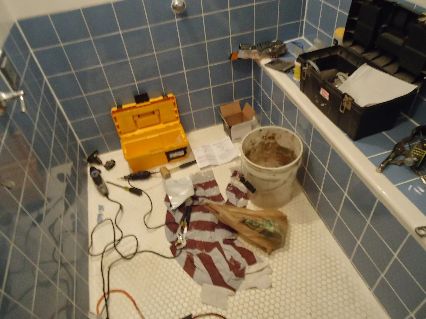 Tools and a toolbox laid out for a bathroom repair