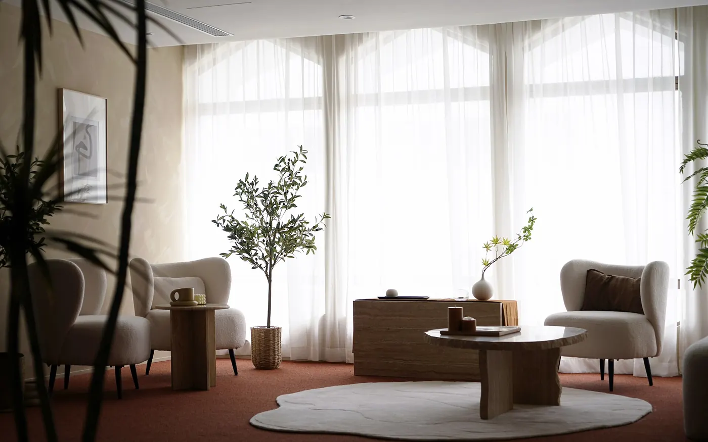 A bright, styled interior with armchairs and sheer curtains