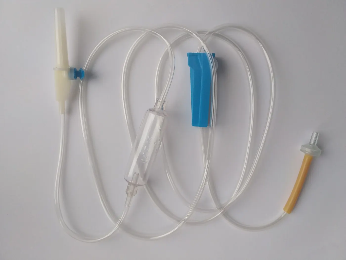 An intravenous drip set laid out on a white surface