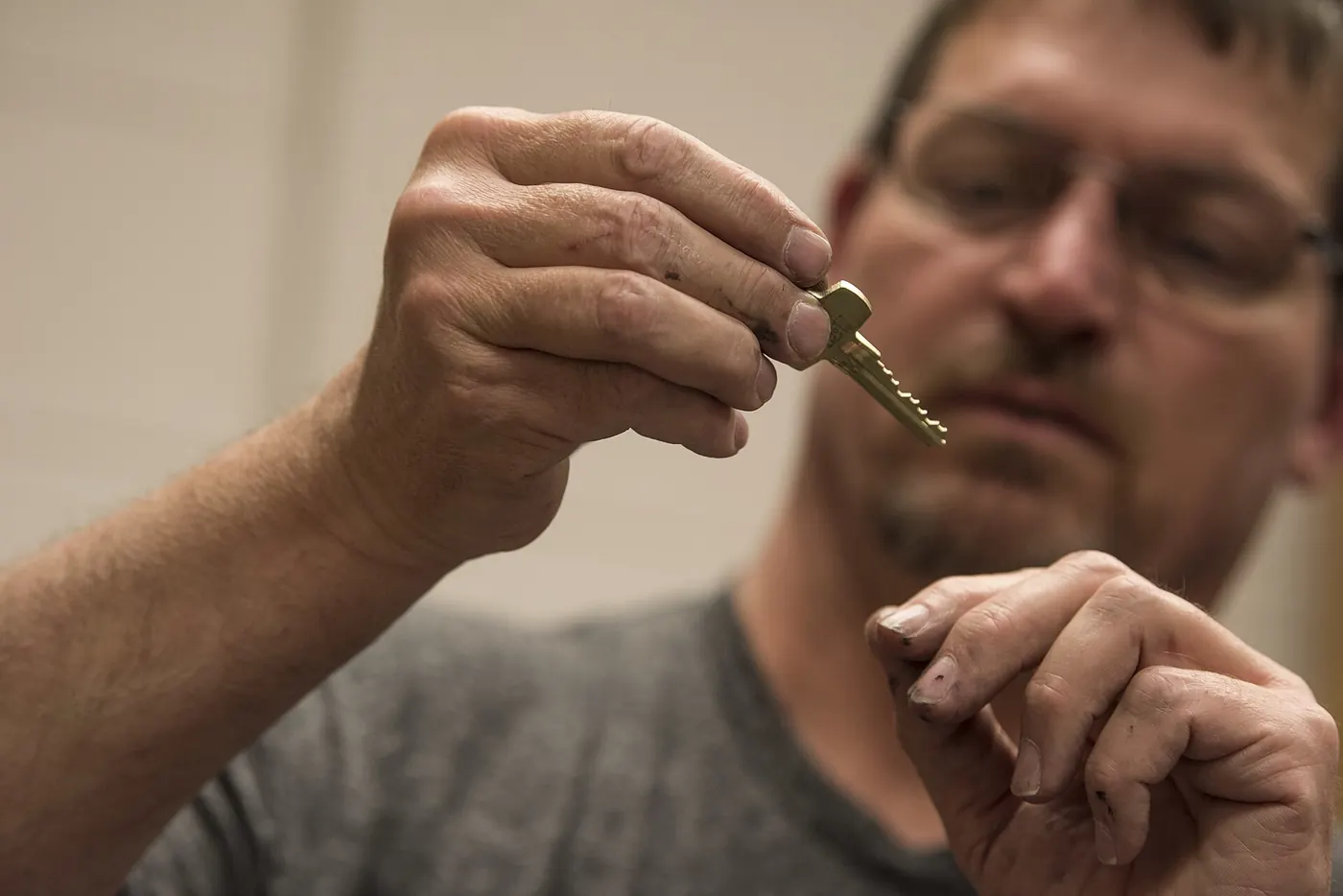 A locksmith inspecting a key