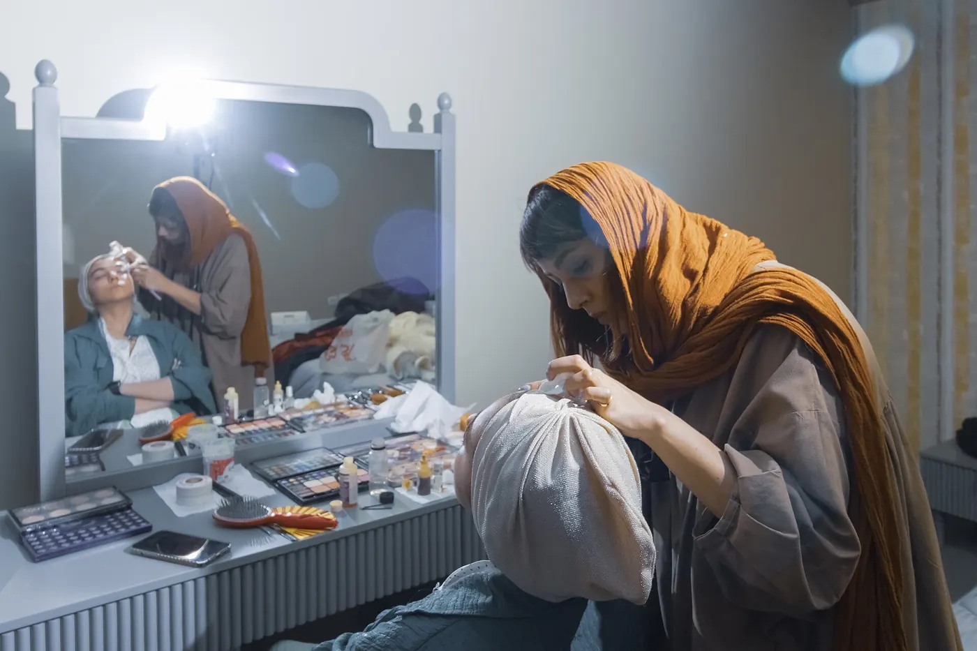 A makeup artist working at a mirror