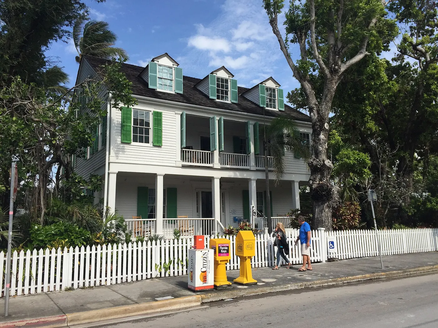 A white house behind a picket fence