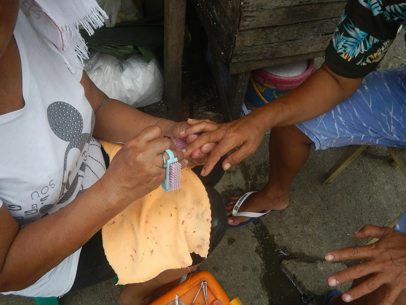 A manicurist painting a client's nails