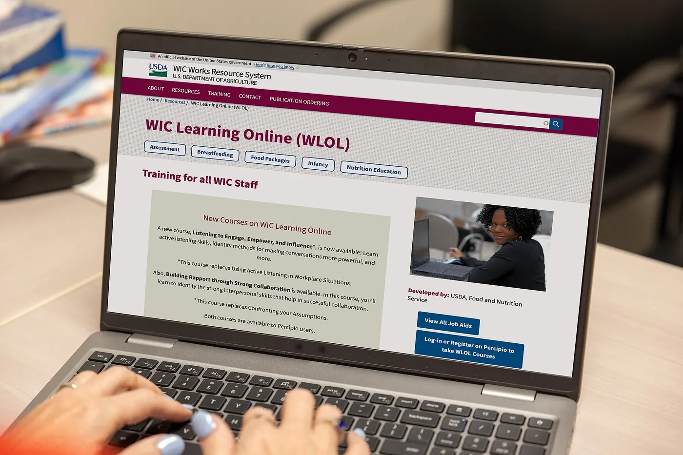 Hands typing on a laptop showing an online course page