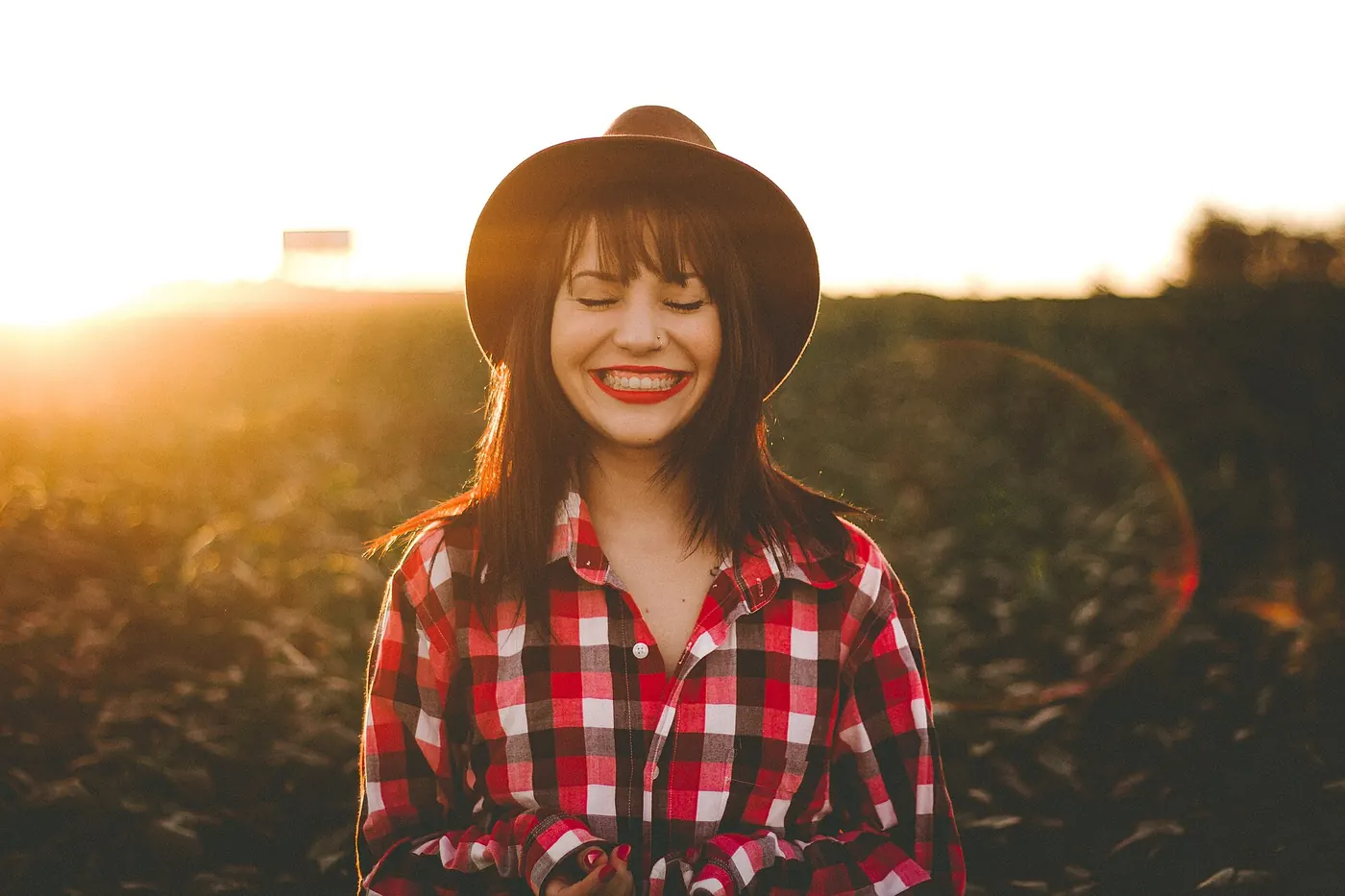 A smiling woman outdoors at golden hour