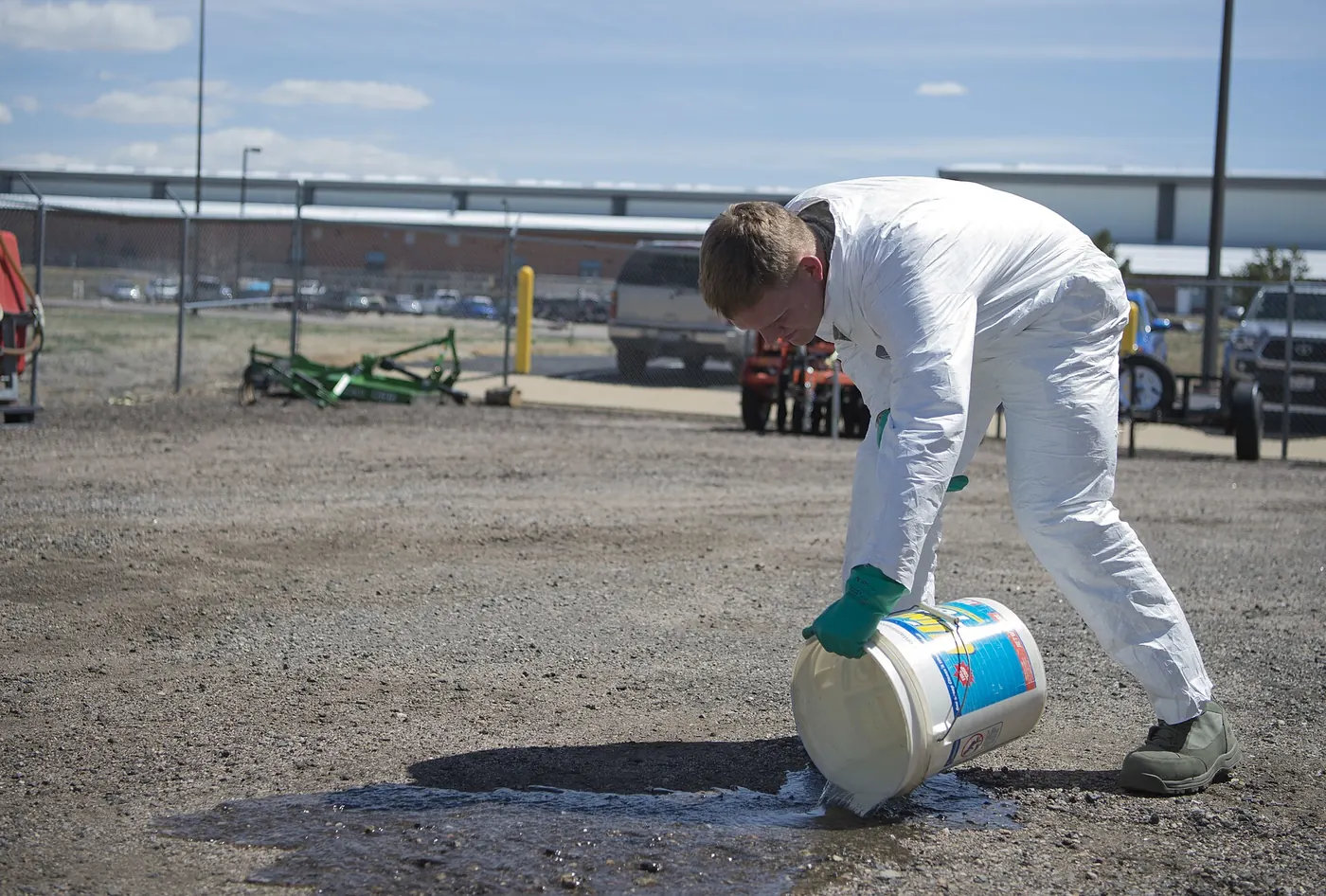 A pest control technician in protective clothing treating an area