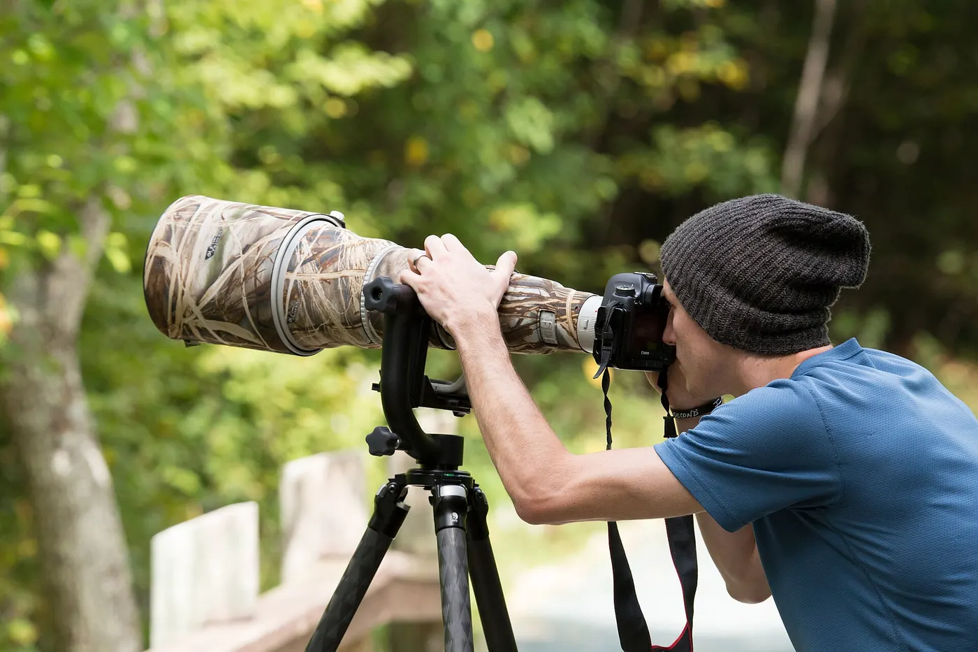 A photographer with a telephoto lens on a tripod