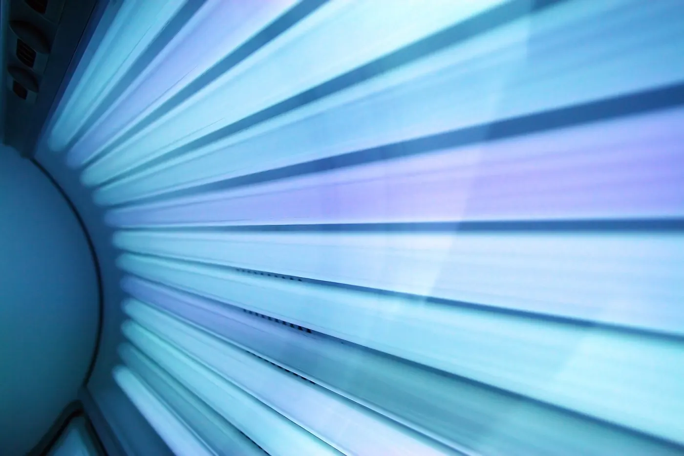 The glowing blue lamps of a tanning bed