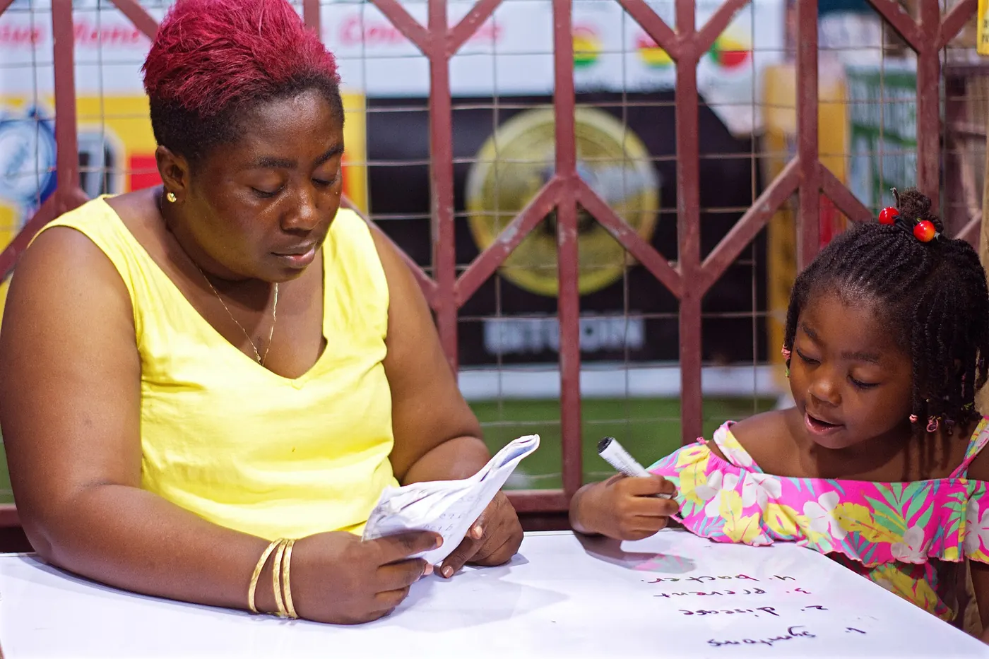 A woman helping a girl with her homework