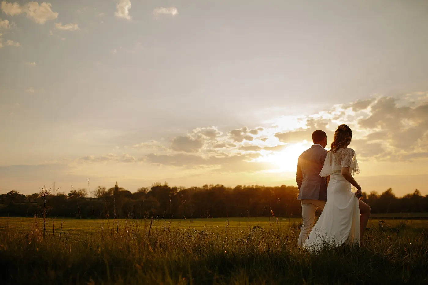 A wedding couple silhouetted at sunset